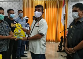 Ketua KONI Sangihe Novilius Tampi memberikan paket bantuan Covid-19 kepada atlet senior disaksikan oleh Bupati Jabes Ezar Gaghana
