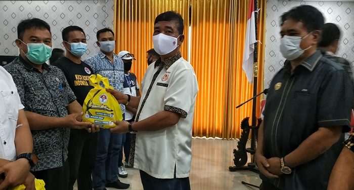 Ketua KONI Sangihe Novilius Tampi memberikan paket bantuan Covid-19 kepada atlet senior disaksikan oleh Bupati Jabes Ezar Gaghana