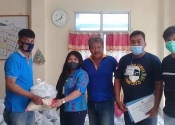 Kabid Jonny Lubis menyerahkan secara simbolis bansos kepada salah satu Lurah di Kecamatan Tuminting.