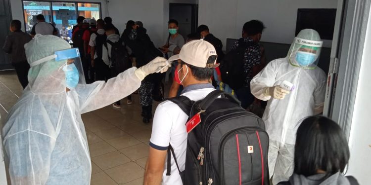 Pemeriksaan dan mengukur suhu tubuh pelaku perjalanan di pintu masuk pelabuhan aktif dilakukan tim satgas. (Foto:Stenly/barta1)