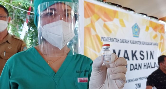 Tenaga kesehatan di Sangihe Sulawesi Utara menunjukkan botol vaksin yang terdistribusi untuk warga (foto: barta1)