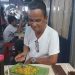Almarhum Wakil Bupati Sangihe, Helmud Hontong, menikmati nasi kuning di Jalan Roda Manado. (Foto: istimewa)