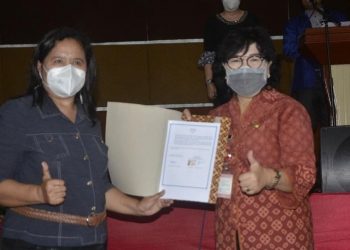 Direktur Polimdo Mareyke Alelo dan Kepala Dikda Sulut Grace Punuh memperlihatkan MoU yang ditandatangani keduanya. (foto: istimewa)