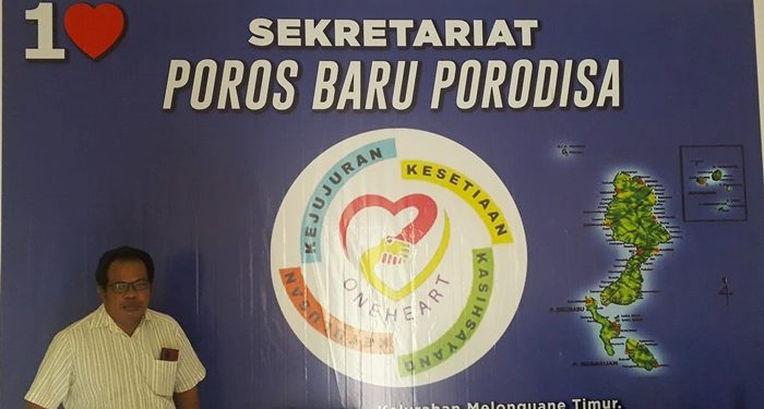 Charles Edah di depan baliho Poros Baru Porodisa