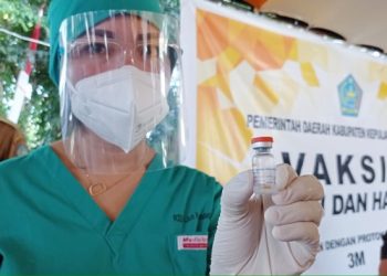 Tenaga kesehatan di Sangihe Sulawesi Utara menunjukkan botol vaksin yang terdistribusi untuk warga (foto: barta1)