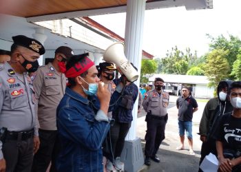 Salah satu peserta aksi melakukan orasi di depan Gedung DPRD Kabupaten Kepulauan Sangihe (Foto: Istimewa)