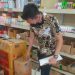 Petugas sedang mengecek ketersediaan bahan pokokdi toko