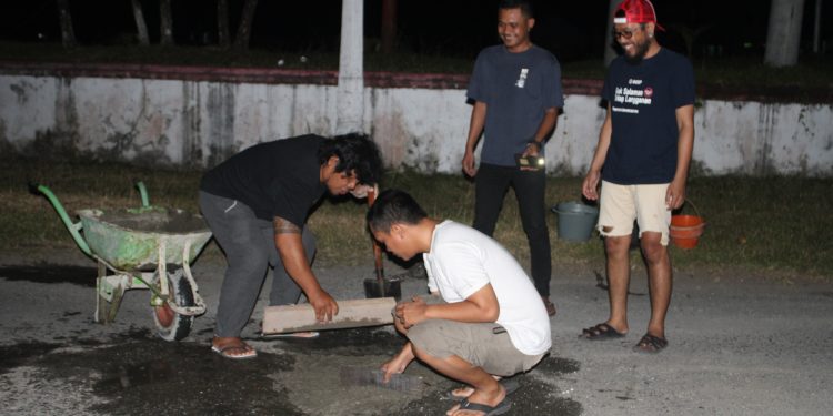 Komunitas Pecinta Kopi Talaud menambal jalan berlubang di seputaran lapangan sangkundiman Melonguane