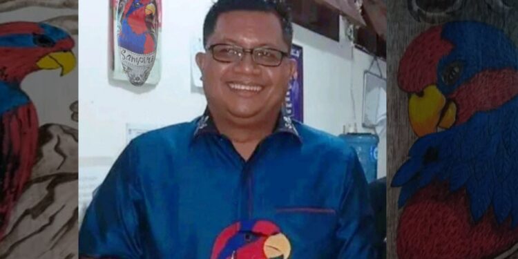 Supriyadi Pangellu, S.H., M.H, sedang mengenakan kemeja bergambar Burung Sampiri.