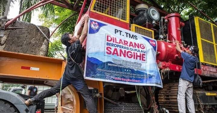 Warga memasang poster penolakan akan kehadiran perusahan tambang di Sangihe. (foto: rendy/barta1)