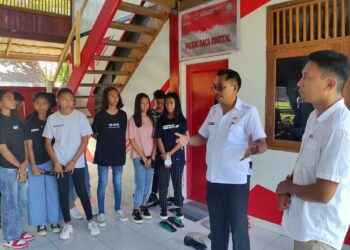 Foto: Kepala Dinas Perpustakaan dan Kearsipan Daerah Kabupaten Kepulauan Sangihe, Johanis Pilat, didampingi Kapitalaung Kamp. Kuma 1, Christian Tapadongko memberikan penjelasan mengenai kegiatan literasi di Pojok Baca Digital kepada anak-anak Kampung Kuma 1. (Dok. Rendy/Barta1)