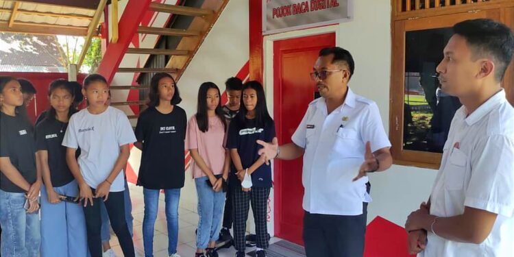Foto: Kepala Dinas Perpustakaan dan Kearsipan Daerah Kabupaten Kepulauan Sangihe, Johanis Pilat, didampingi Kapitalaung Kamp. Kuma 1, Christian Tapadongko memberikan penjelasan mengenai kegiatan literasi di Pojok Baca Digital kepada anak-anak Kampung Kuma 1. (Dok. Rendy/Barta1)
