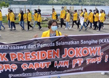 Mahasiswi membentangkan spanduk menolak kehadiran korporasi tambang di Pulau Sangihe. (foto: Rendy/Barta1)