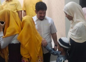 Ketua Fraksi Golkar Sulut, Raski Mokodompit saat berjabat tangan dengan anak yatim (Foto: Meikel/Barta1com