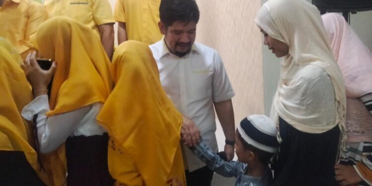 Ketua Fraksi Golkar Sulut, Raski Mokodompit saat berjabat tangan dengan anak yatim (Foto: Meikel/Barta1com