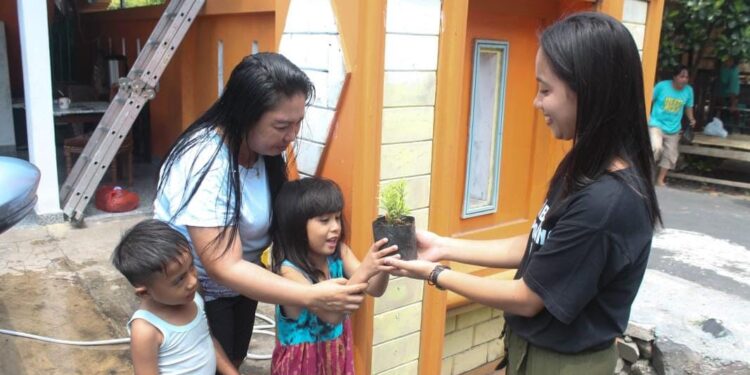 Anggota Rukun Sembihingang Polimdo saat memberikan bunga hias kepada masyarakat (Foto Meikel Barta1.com)