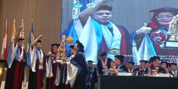 Penyerahan piala bergilir oleh Diretur Polimdo Dra Mareyke Alelo MBA kepada Ketua dan Sekretaris Jurusan Elektro. (Foto: meikel/barta1)