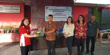 ketua jurusan Administrasi Bisnis Polimdo, Juliet Makinggung, SE.,MSi saat memberikan bantuan kelengkapan kearsiapan kepada perangkat kelurahan di Mapanget. (Foto: meikel/barta).