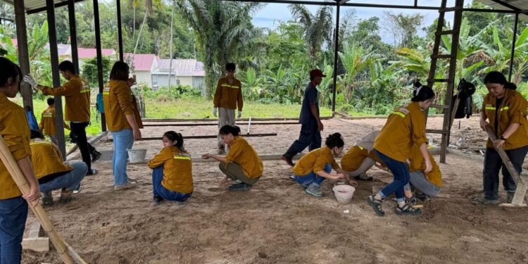 Tim PPM-M Polimdo pada proses pembuatan lantai dan dinding sekolah MI dan MT's Siar Sunah. (Foto: istimewa)
