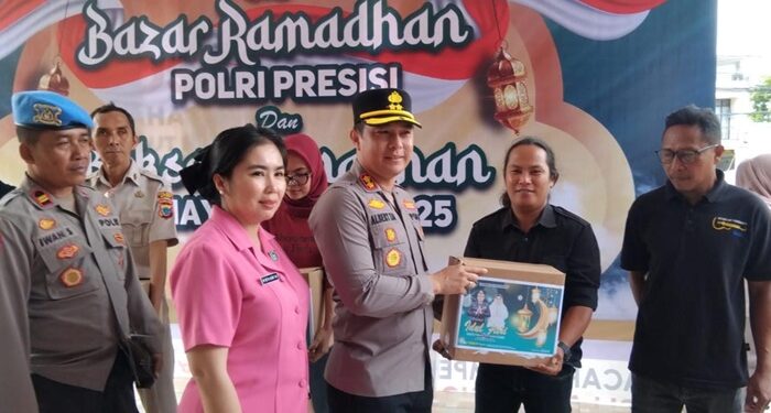 Kapolres Bitung AKBP Albert Zai bersama Ketua Bhayangkari cabang Bitung Ny Detta Albert Zai saat membagikan paket sembako. (foto: Chris/Barta1)