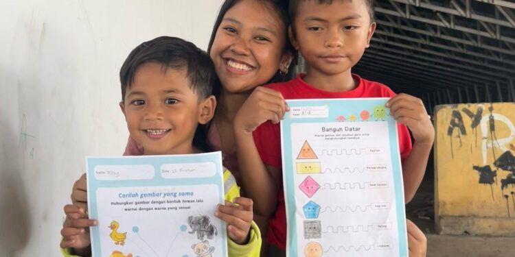 Putu Sri Dharmayanti bersama dua anak Paud di Dinding Manado. (foto: istimewa)