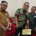 Wakil Ketua Komisi IV DPRD Provinsi Sulut, Louis Carl Schramm yang didampingi oleh PLT Sekwan Niklas Silangen beserta anak kecil yang orang tuanya menjadi bagian dari TPPO Kamboja. (Foto: meikel/barta)