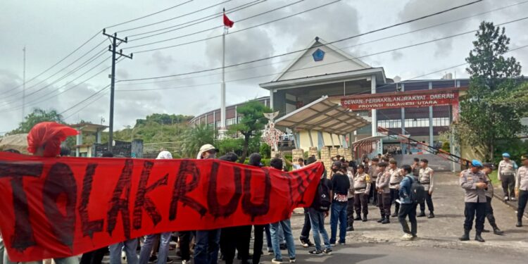 Massa aksi bentangkan spanduk Tolak RUU TNI. (Foto: meikel/barta)