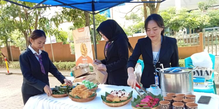 Mahasiswi Jurusan Pariwisata Polimdo sedang mengatur kue tradisional. (foto: meikel/barta)
