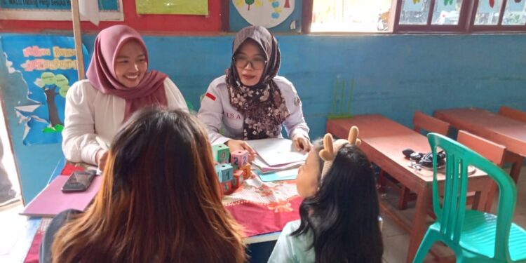 Dua akademisi dari Universitas Muhamadiyah saat memberikan pemeriksaan kesehatan kepada anak-anak. (foto: meikel/barta)