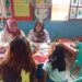 Dua akademisi dari Universitas Muhamadiyah saat memberikan pemeriksaan kesehatan kepada anak-anak. (foto: meikel/barta)