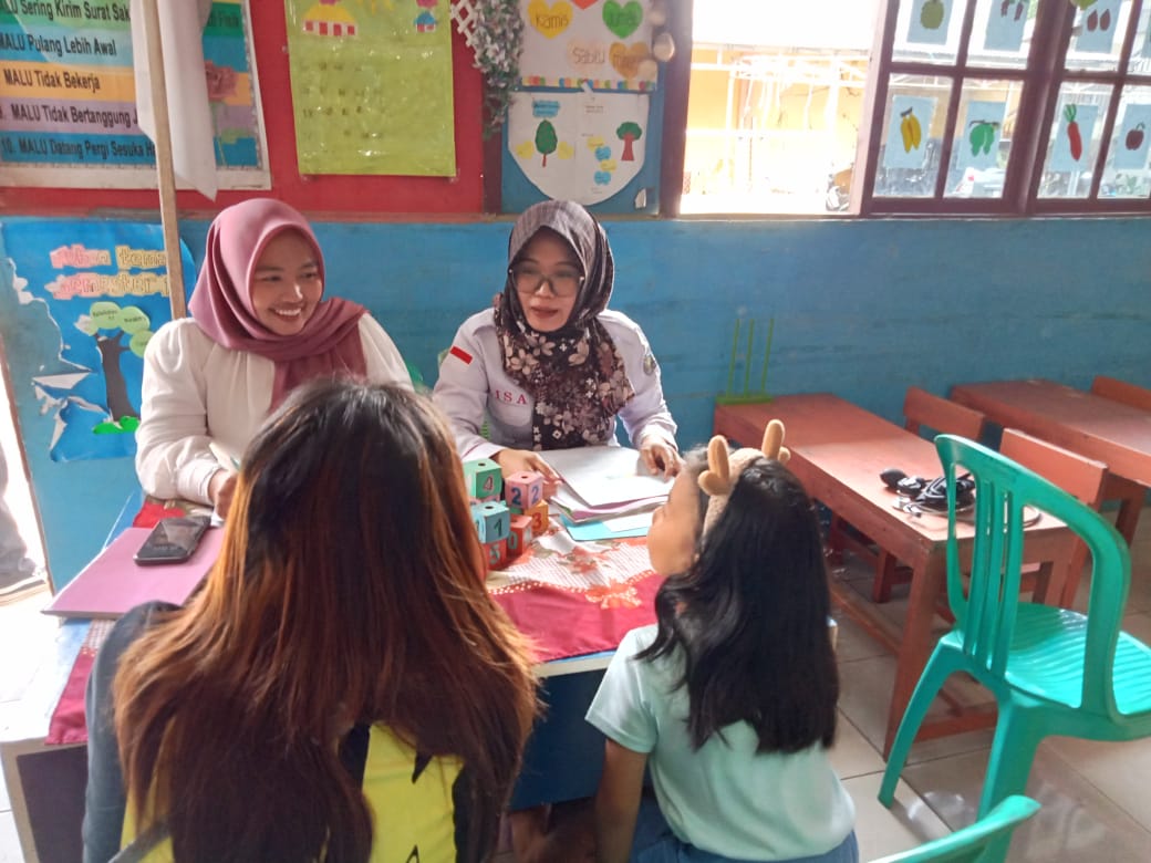 Dua akademisi dari Universitas Muhamadiyah saat memberikan pemeriksaan kesehatan kepada anak-anak. (foto: meikel/barta)