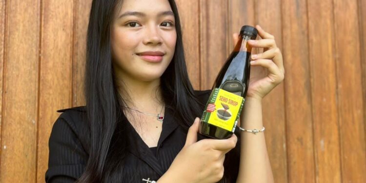 Noni De La Salle Tahun 2024, Brigita Abigail, saat memegang produk L’Arbre Seho, yakni Seho Sirop . (foto: istimewa)