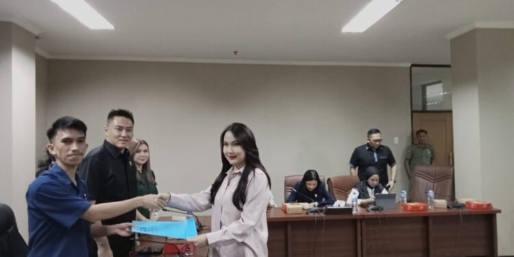 Anggota Fraksi Demokrat, Angel Wenas, menyerahkan pandangan Fraksi ke Ketua Pansus Kepemudaan, Eldo Wongkar. (foto: meikel/barta)