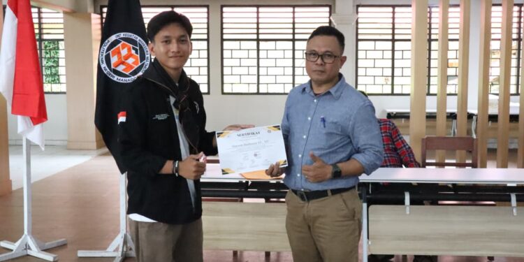 Ketua umum UKM Multimedia , Dicky Makapuas menyerahkan piagam kepada pemateri, yakni Kepala Jurusan Teknik Elektro Polimdo, Marson Budiman SST., MT. (foto: istimewa)