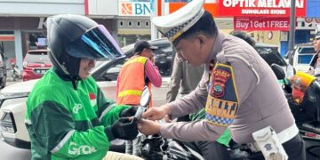 Satlantas Polres Bitung bagikan Bendera Merah Putih ke pengemudi Ojek Online. (foto: Chris/Barta1)