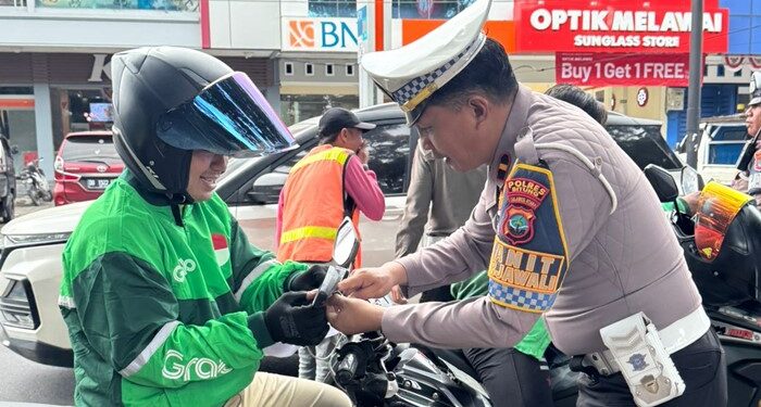 Satlantas Polres Bitung bagikan Bendera Merah Putih ke pengemudi Ojek Online. (foto: Chris/Barta1)