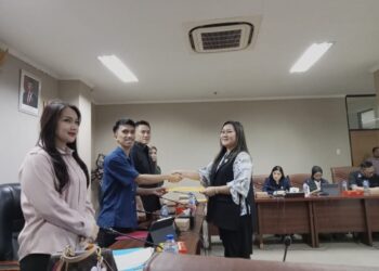 Anggota DPRD Sulut, Vionita Kuera, saat menyerahkan pandangan Fraksi Golkar kepada ketua Pansus Kepemudaan. (foto: meikel/barta)
