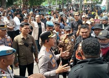 Kapolres Bitung AKBP Albert Zai, SIK, MH, melakukan negosiasi dengan para pengunjuk rasa di depan pintu masuk DPRD Kota Bitung. (foto: Chris/Barta1)