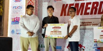Koordinator Liputan Barta1 Ady Putong dan Kepala Perwakilan Bank Indonesia Sulut Ircham Taufik menyerahkan hadiah pada juara I penulisan artikel Festival Kuliner Kemerdekaan. (foto: Ikel Labaro)