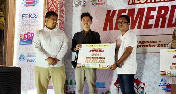 Koordinator Liputan Barta1 Ady Putong dan Kepala Perwakilan Bank Indonesia Sulut Ircham Taufik menyerahkan hadiah pada juara I penulisan artikel Festival Kuliner Kemerdekaan. (foto: Ikel Labaro)