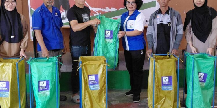 Tim pengabdian kepada masyarakat Polimdo bersama masyarakat dan pemerintah Uluindano: menyerahkan alat pengolahan sampah rumahan. (foto: istimewa)