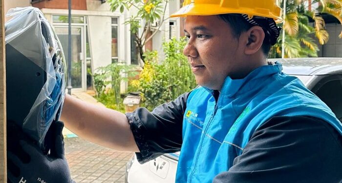 Petugas PLN saat melakukan pemasangan home charger di rumah pelanggan untuk memudahkan pengisian kendaraan listrik di rumah. (foto: Humas PLN)