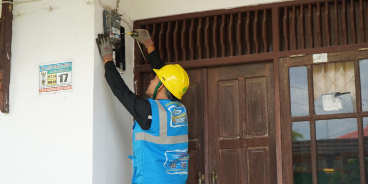 petugas PLN saat melakukan penggantian Miniature Circuit Breaker (MCB) pada kWh meter pelanggan yang melakukan tambah daya listrik. (Foto: Humas PLN)