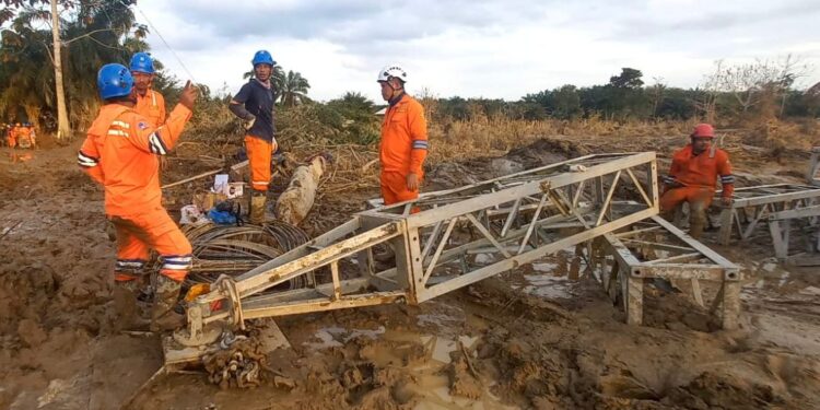 Di tengah medan yang berlumpur, petugas PLN melakukan perakitan tower darurat di jalur transmisi Langsa-Pangkalan Brandan. (foto: Humas PLN)