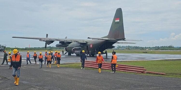 Para petugas PLN bersama personel TNI saat akan memasukkan material perbaikan dan pembangunan jaringan distribusi baru untuk dikirim ke lokasi-lokasi terdampak menggunakan pesawat Hercules. (foto: Humas PLN)