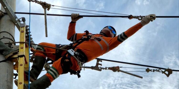 Personel PLN melakukan penarikan kabel Saluran Udara Tegangan Menengah di Panton Labu Aceh Utara. (foto: Humas PLN)