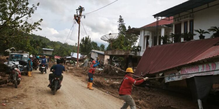 Petugas PLN melakukan penarikan kabel untuk disambungkan ke tiang-tiang listrik jaringan tegangan rendah baru di Kabupaten Agam. (foto: Humas PLN)