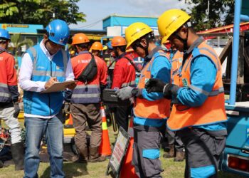 Petugas PLN sedang melakukan pengecekan kepada petugas pelayanan teknik sebagai bentuk prosedur kerja yang harus dijalani sebelum melaksanakan pekerjaan di lapangan. (foto: Humas PLN)