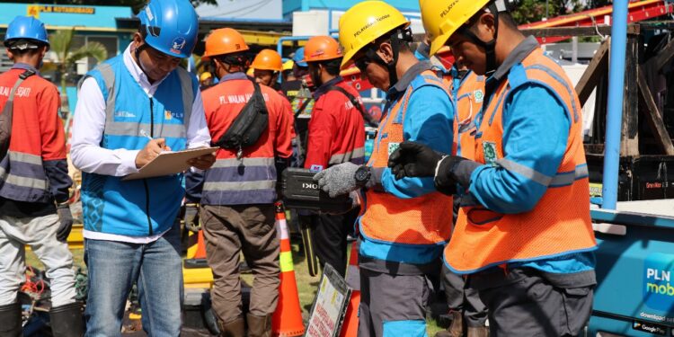 Petugas PLN sedang melakukan pengecekan kepada petugas pelayanan teknik sebagai bentuk prosedur kerja yang harus dijalani sebelum melaksanakan pekerjaan di lapangan. (foto: Humas PLN)