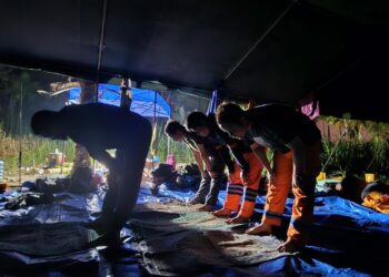 Petugas PLN tampak sedang beribadah di sela kerja tanpa henti menyalakan sistem kelistrikan pascabencana. (foto: Humas PLN)